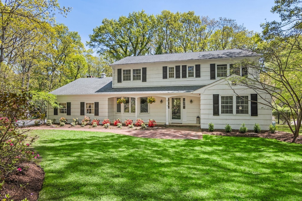16 Southgate Rd, Setauket, NY 11733 - view of front facade with a shingled roof, a front lawn, and a patio area