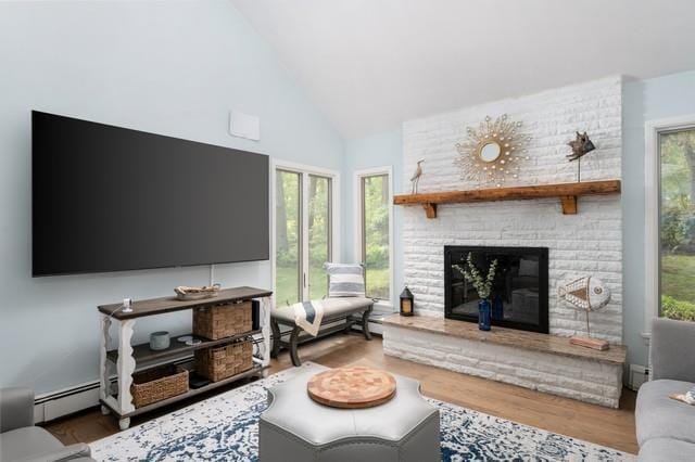 6 Circle Dr, Shoreham, NY 11786 - living room featuring a baseboard heating unit, high vaulted ceiling, wood finished floors, and a large fireplace