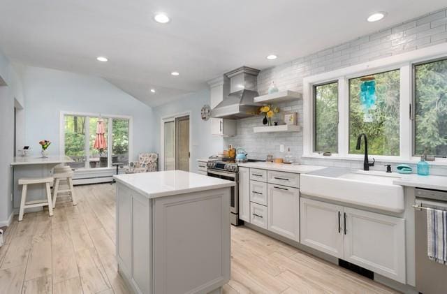6 Circle Dr, Shoreham, NY 11786 - kitchen with stainless steel appliances, wall chimney exhaust hood, lofted ceiling, a center island, and light countertops