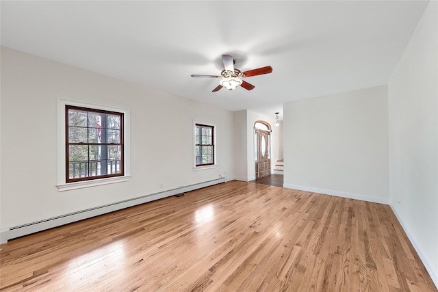 spare room with ceiling fan, a baseboard heating unit, and light wood-style flooring