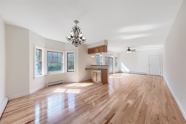 interior space with plenty of natural light, a baseboard heating unit, and light wood-style flooring