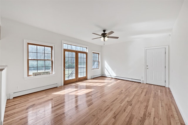spare room featuring light wood-style floors, baseboard heating, a ceiling fan, and french doors