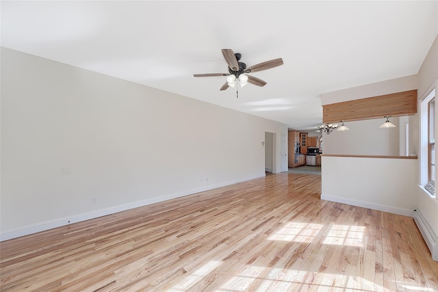 spare room with baseboards, light wood finished floors, and ceiling fan with notable chandelier