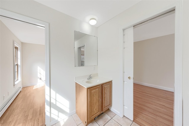 bathroom featuring vanity, baseboards, baseboard heating, and wood finished floors
