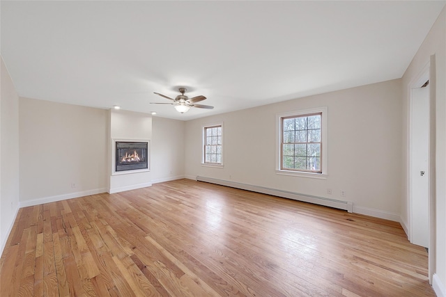 unfurnished living room with baseboards, a baseboard radiator, and light wood finished floors
