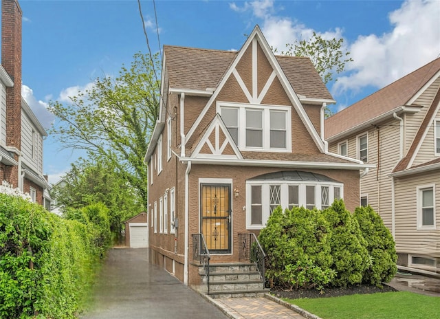 39 Crestmont Ave, Yonkers, NY 10704 - tudor house featuring an outdoor structure, a detached garage, stucco siding, and roof with shingles