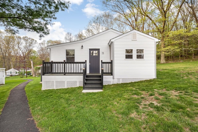 rear view of house with a yard and a deck