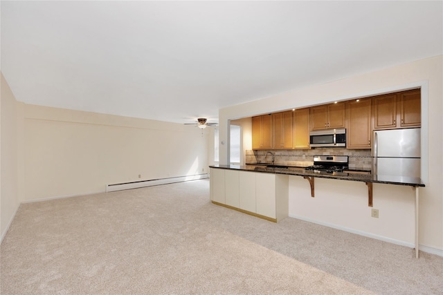 40 Daley Pl Unit 230, Lynbrook, NY 11563 - kitchen featuring appliances with stainless steel finishes, a baseboard radiator, and light colored carpet