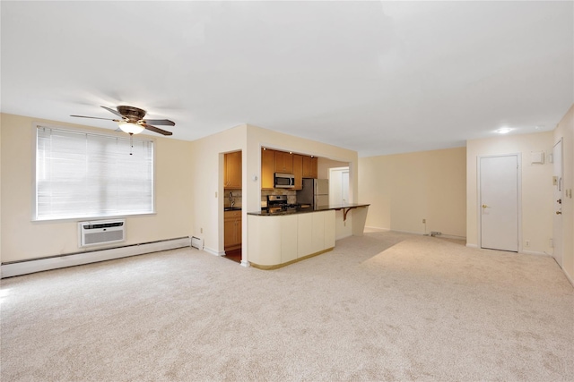 40 Daley Pl Unit 230, Lynbrook, NY 11563 - unfurnished living room featuring a baseboard radiator, light colored carpet, ceiling fan, baseboards, and a wall unit AC