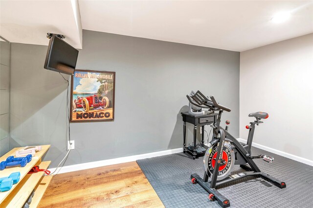 workout room featuring baseboards and wood finished floors