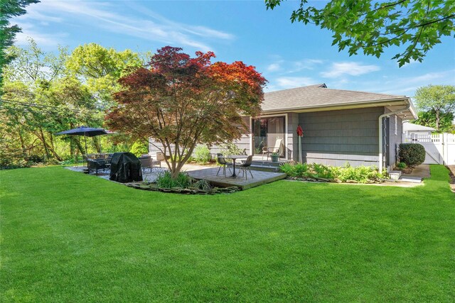 rear view of property featuring roof with shingles and a patio
