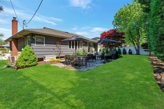 rear view of property with a chimney, a patio, central AC, and roof with shingles
