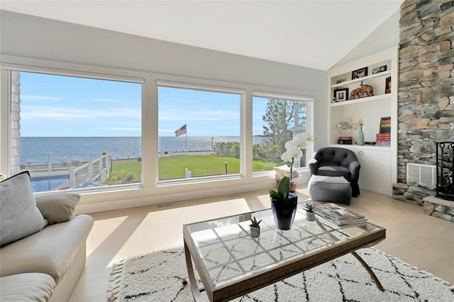 living area with a water view, high vaulted ceiling, and built in features
