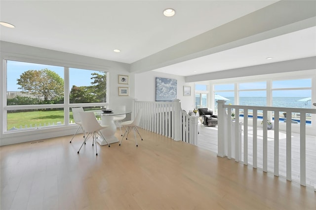 interior space with a water view, wood finished floors, visible vents, and recessed lighting