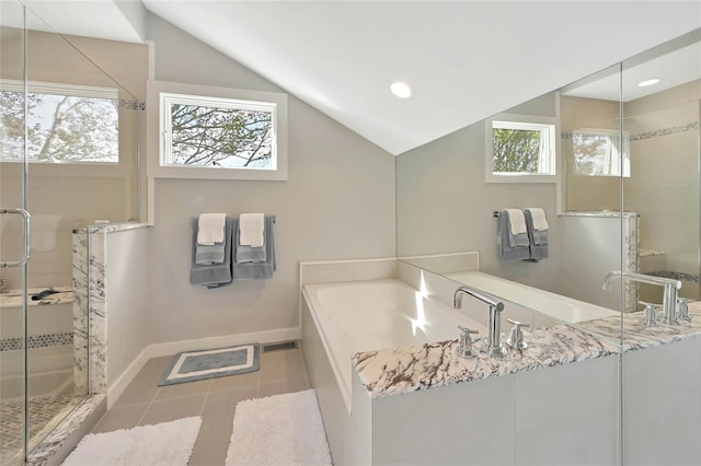 full bathroom featuring lofted ceiling, a garden tub, plenty of natural light, and a stall shower