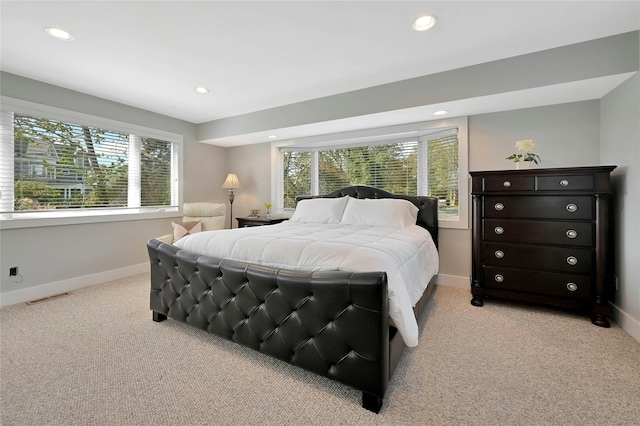 bedroom featuring baseboards, recessed lighting, light carpet, and visible vents