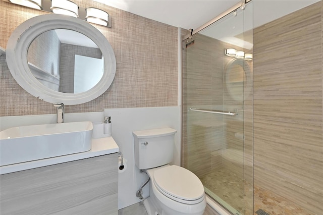 bathroom featuring vanity, toilet, tile walls, and a stall shower