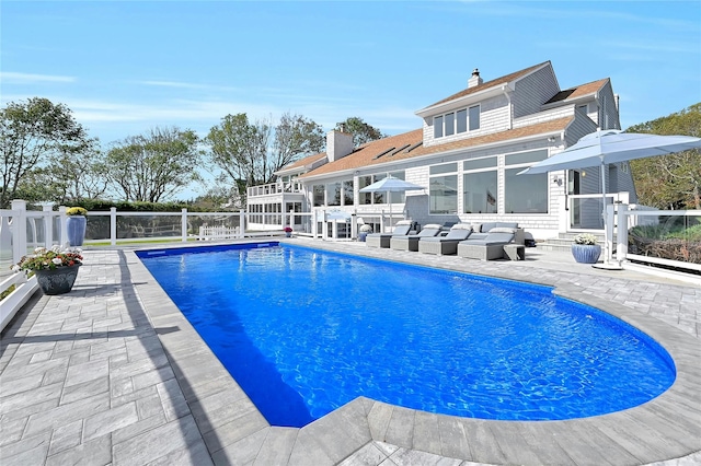 view of swimming pool with an outdoor living space, a patio area, a fenced in pool, and fence