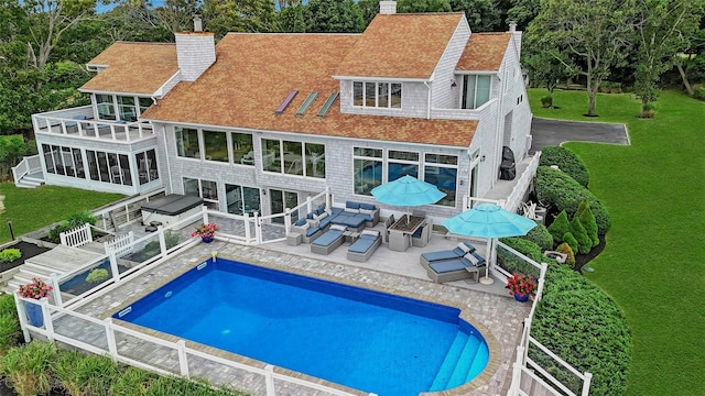 rear view of property featuring outdoor lounge area, roof with shingles, a chimney, and a balcony