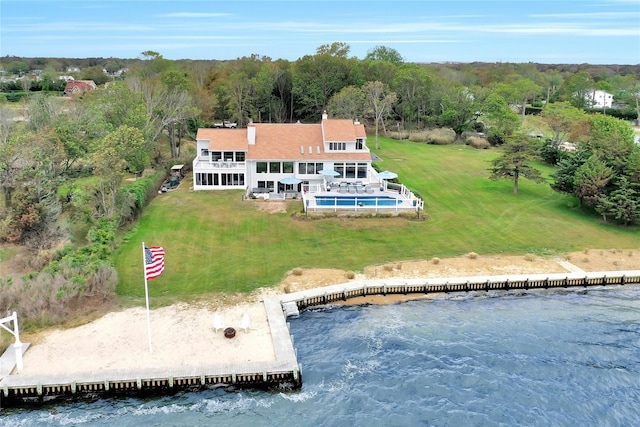 birds eye view of property with a water view and a view of trees