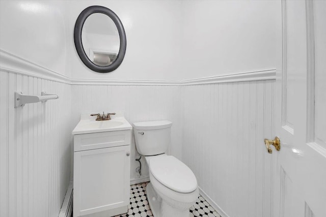 83 Sherwood Rd, Cortlandt Manor, NY 10567 - half bathroom featuring toilet, vanity, a wainscoted wall, and baseboard heating