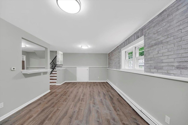 83 Sherwood Rd, Cortlandt Manor, NY 10567 - unfurnished room with a baseboard heating unit, stairway, wood finished floors, and baseboards