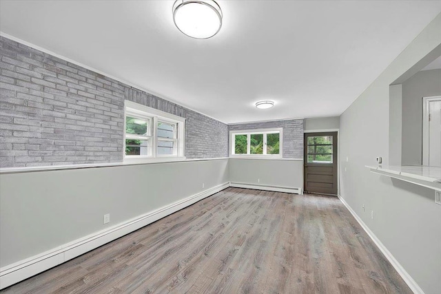 83 Sherwood Rd, Cortlandt Manor, NY 10567 - unfurnished room with a baseboard radiator, wood finished floors, baseboards, and brick wall