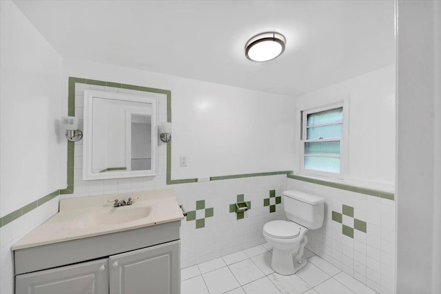 83 Sherwood Rd, Cortlandt Manor, NY 10567 - half bath with tile walls, toilet, vanity, tile patterned flooring, and a wainscoted wall