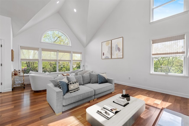 living room featuring recessed lighting, baseboards, high vaulted ceiling, and wood finished floors