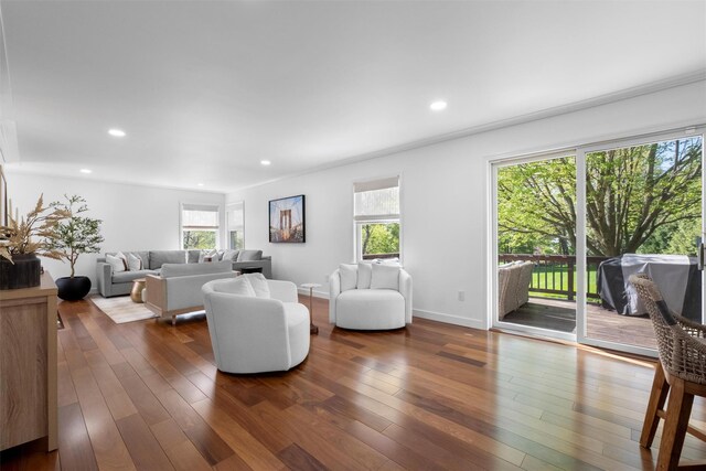 living room featuring dark wood-style flooring, plenty of natural light, and recessed lighting