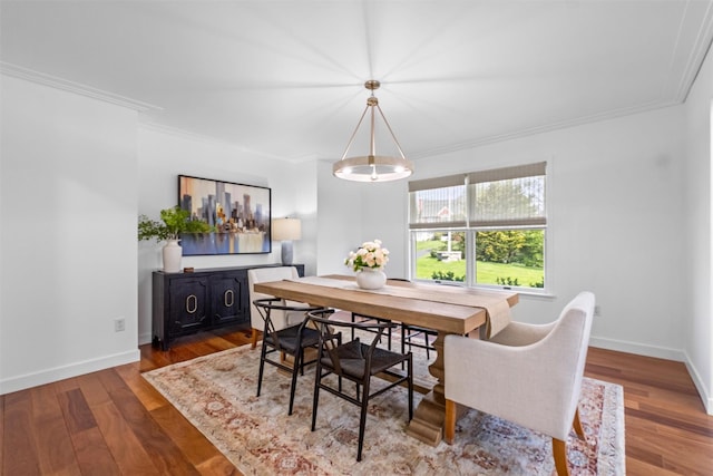 dining room featuring crown molding, wood finished floors, and baseboards