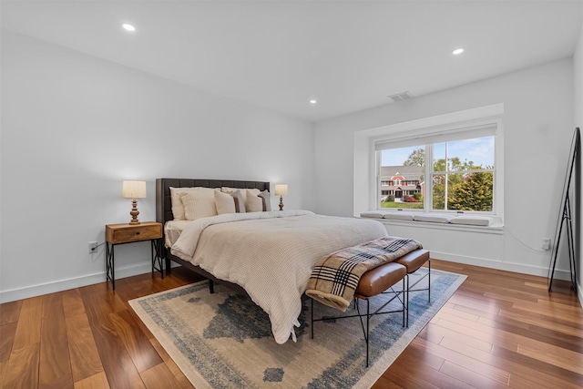 bedroom featuring wood finished floors, visible vents, baseboards, and recessed lighting
