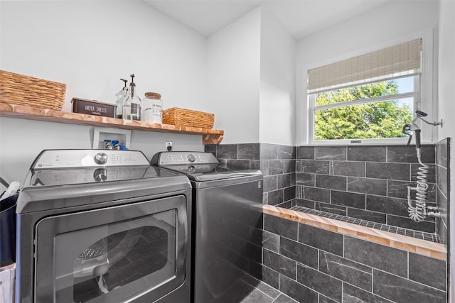 clothes washing area featuring separate washer and dryer and laundry area