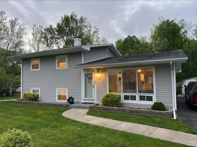 split level home with a front lawn and a chimney