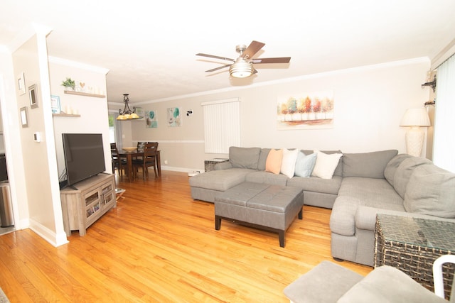 living room with crown molding, ceiling fan, baseboards, and light wood-style floors