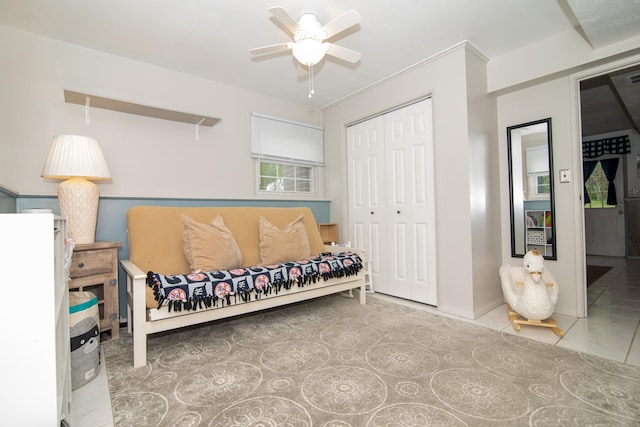tiled bedroom with a closet, baseboards, and a ceiling fan