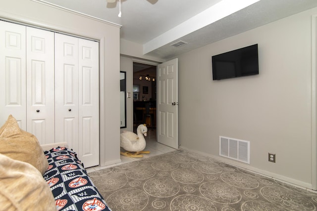 tiled bedroom featuring a closet, baseboards, and ceiling fan