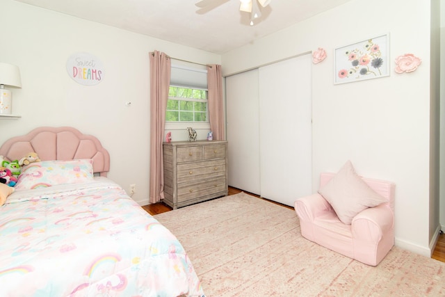 bedroom with a closet, wood finished floors, and ceiling fan