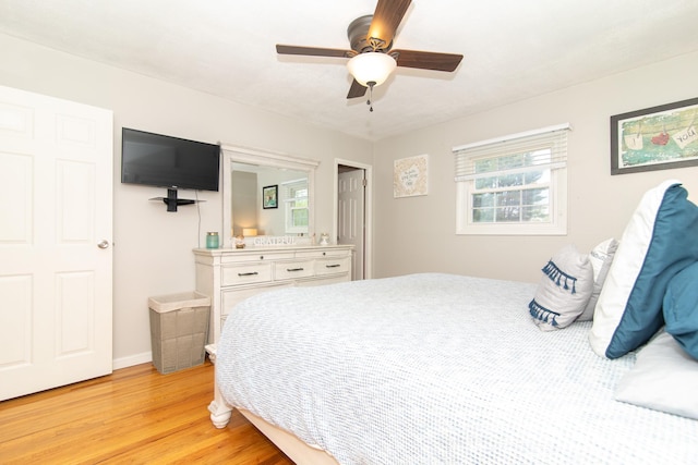 bedroom featuring light wood-style floors, ceiling fan, and baseboards