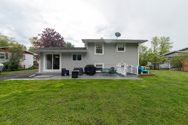 rear view of house with a lawn and a patio area