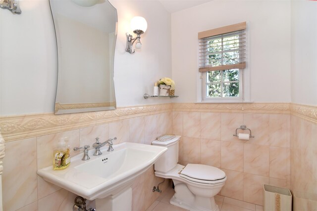 668 Francis St, Pelham, NY 10803 - bathroom featuring a sink, tile walls, toilet, tile patterned flooring, and wainscoting