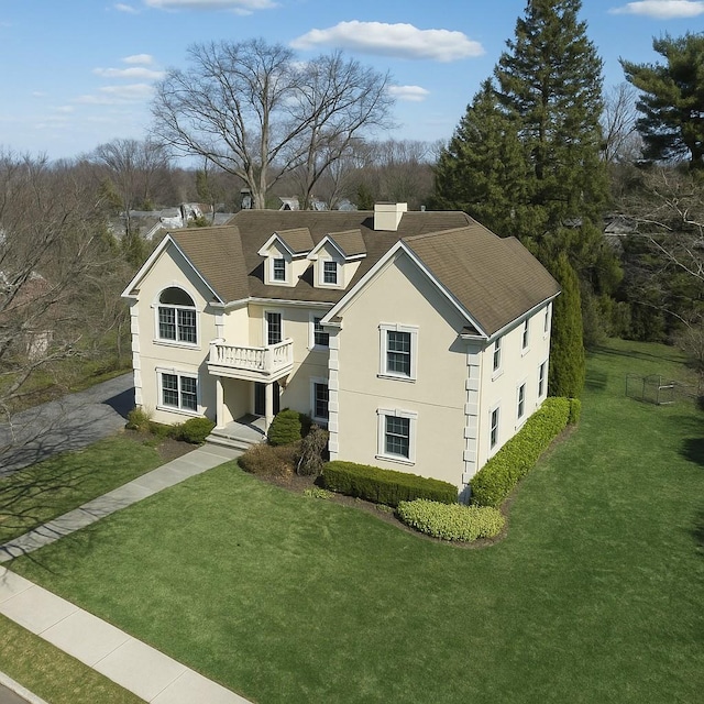 668 Francis St, Pelham, NY 10803 - traditional-style home with stucco siding, a balcony, a front lawn, and a shingled roof