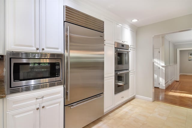 668 Francis St, Pelham, NY 10803 - kitchen with appliances with stainless steel finishes, white cabinets, baseboards, and recessed lighting