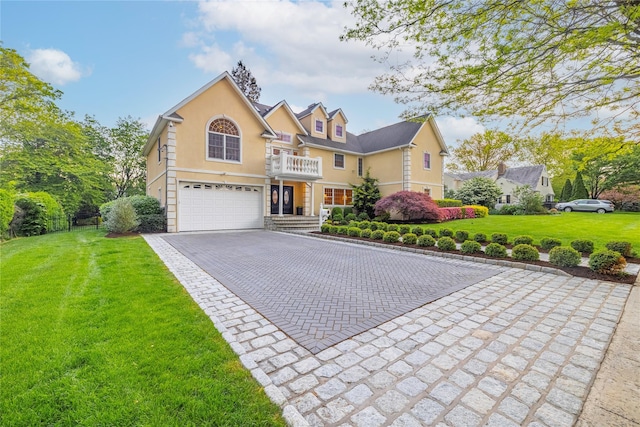 668 Francis St, Pelham, NY 10803 - traditional-style home featuring an attached garage, decorative driveway, stucco siding, a front yard, and a balcony