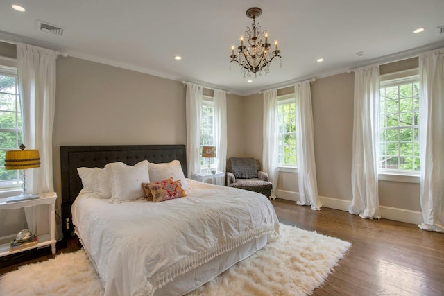 bedroom with multiple windows, crown molding, baseboards, a chandelier, and wood finished floors