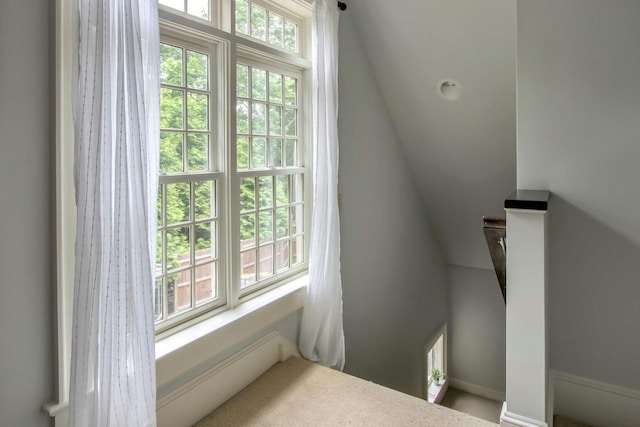stairway featuring plenty of natural light and baseboards