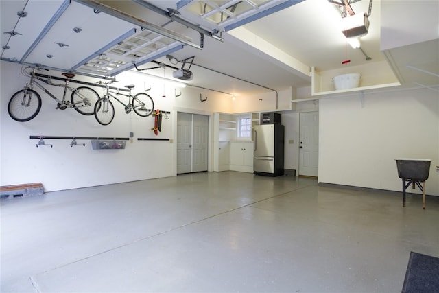 garage with freestanding refrigerator and a garage door opener