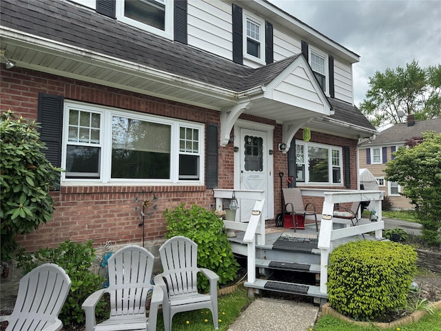 5 W Stone St, Newburgh, NY 12550 - doorway to property featuring brick siding and a shingled roof
