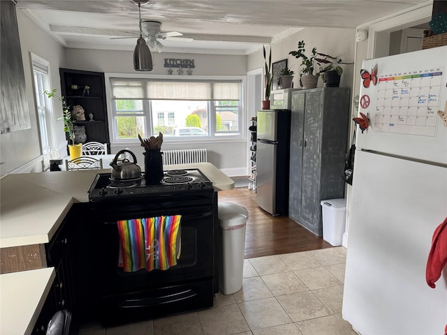5 W Stone St, Newburgh, NY 12550 - kitchen with freestanding refrigerator, electric range, radiator heating unit, and a ceiling fan