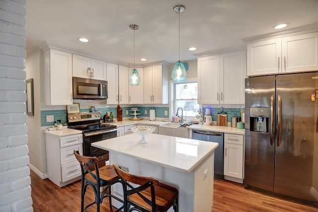 21 Potter Ln, Levittown, NY 11756 - kitchen featuring appliances with stainless steel finishes, white cabinets, a kitchen island, tasteful backsplash, and recessed lighting